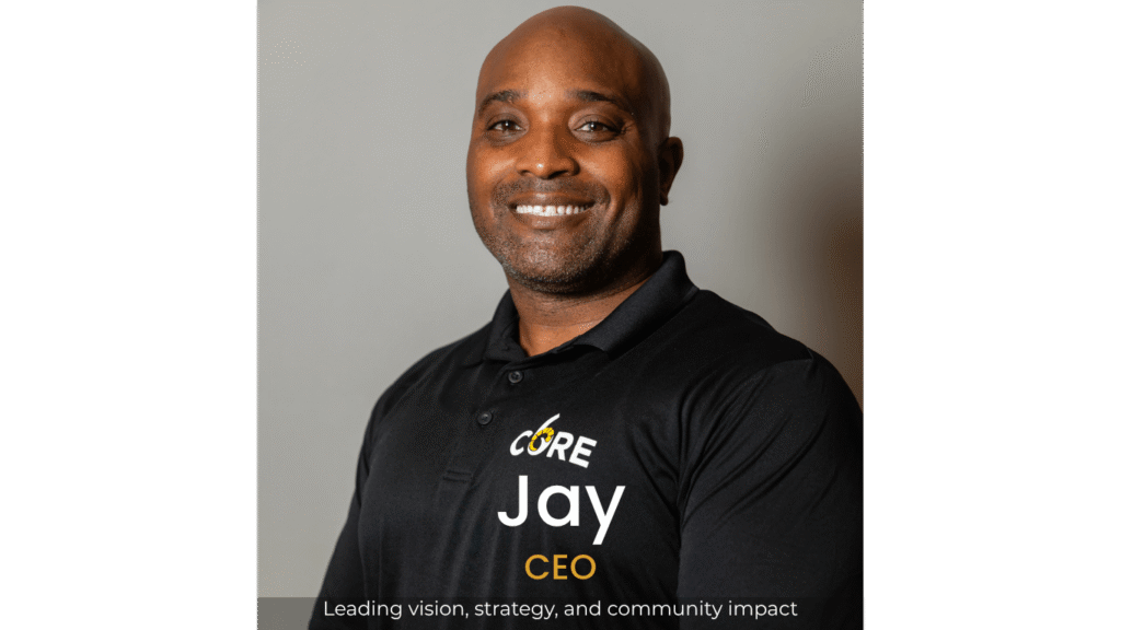Smiling person in black polo with logo